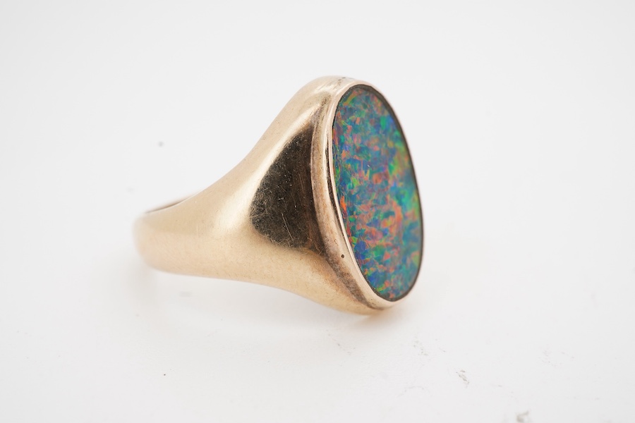 An opal doublet signet ring, set with a polished black opal measuring approximately 14.7 x 9 x 2.8mm, within a gold mount, size O, stamped 14K, gross weight approximately 6 grams